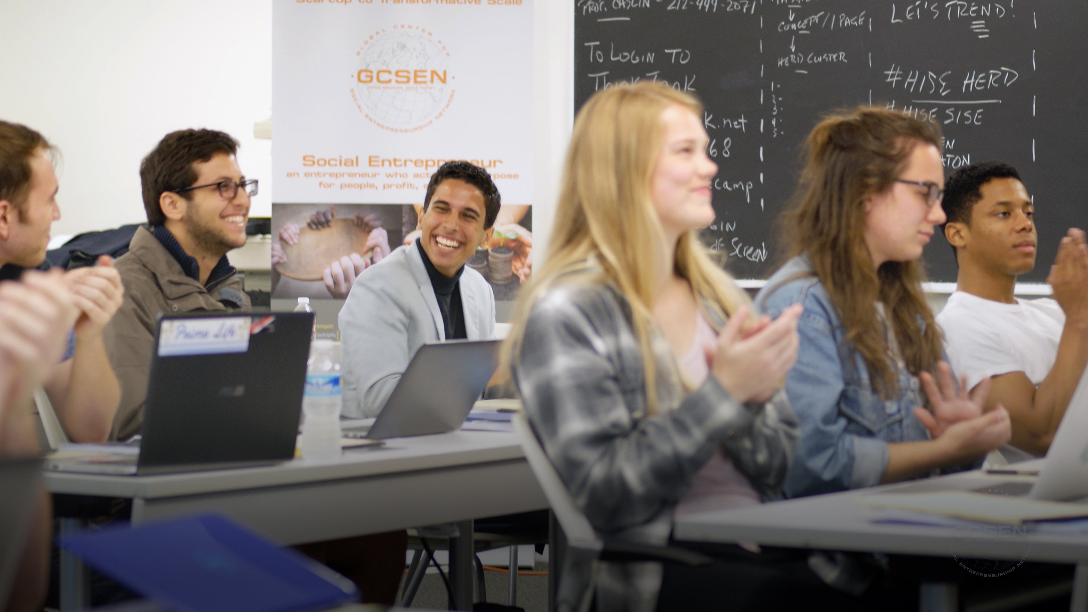 students laughing and clapping seated in classroom